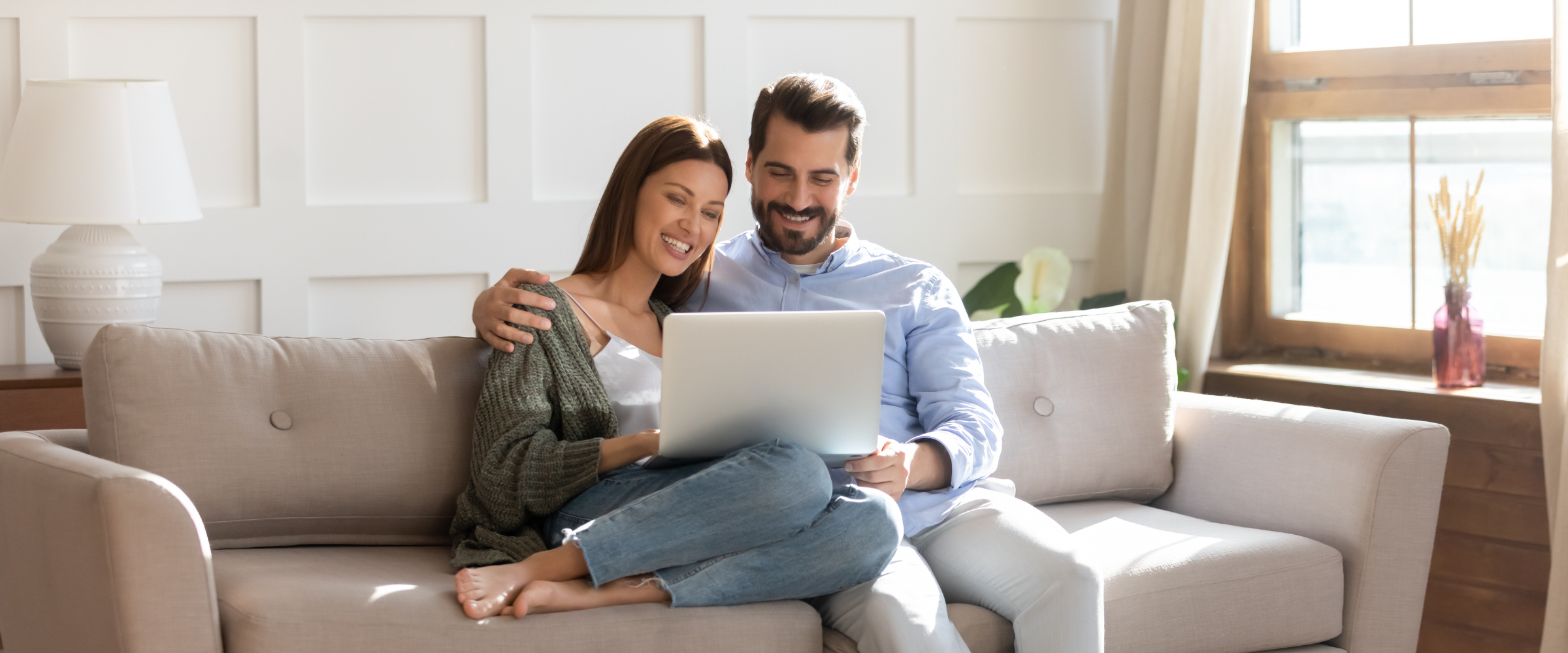 Happy couple reading blog on couch