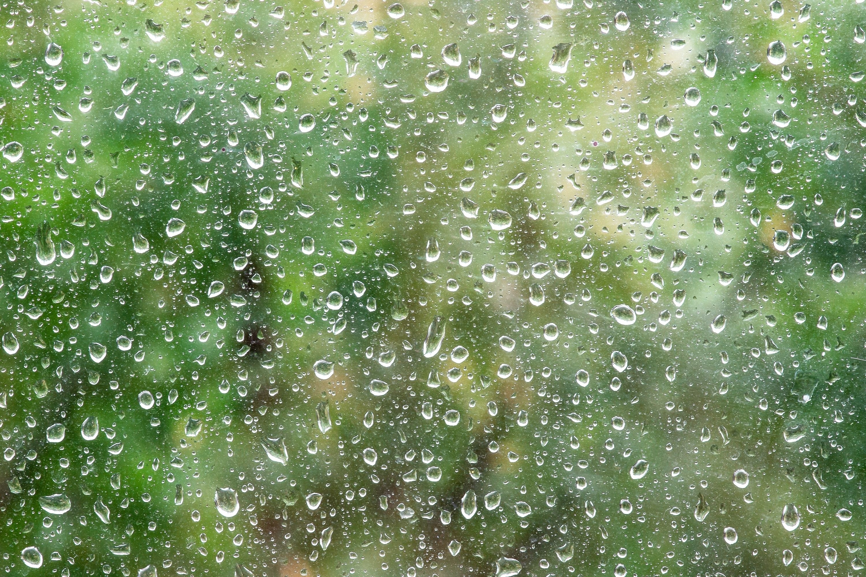 Rain drops close up on window glass outdoors.