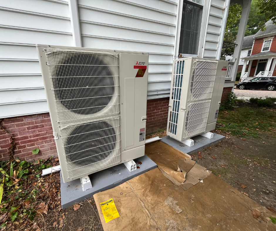 Heat pump(s) installed outside white, residential home in MD by Total Home Performance