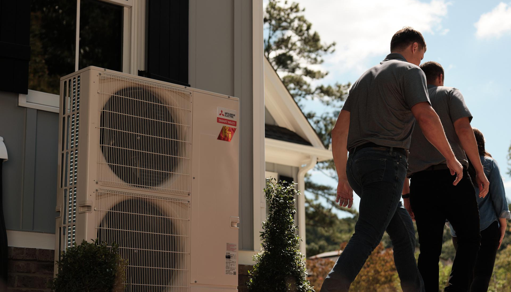 THP staff walking away from Mitsibushi Electric heat pump they've just installed at a Maryland home