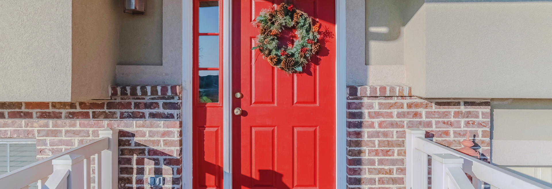 Red front door of home with decorative wreath