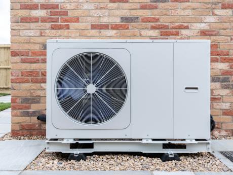 Ducted heat pump unit on the outside of brick home