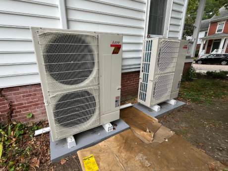 Heat pump(s) installed outside white, residential home in MD by Total Home Performance