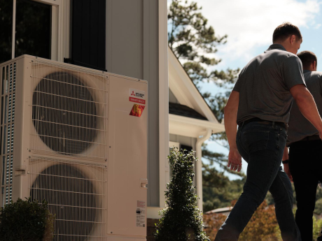 THP staff walking away from Mitsibushi Electric heat pump they've just installed at a Maryland home