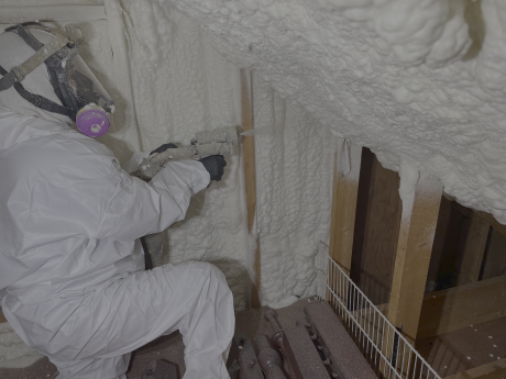 Member of the Total Home Performance team spraying insulation in home