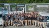 Total home performance team standing in front of branded trucks & vans