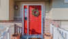Red front door of home with decorative wreath